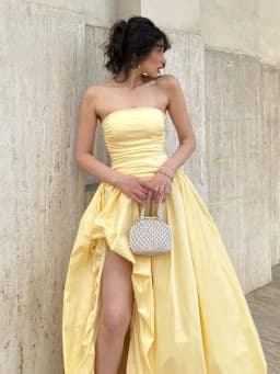 Elegantní žluté plisované šaty bez ramínek s vysokým pasem a rozparkem pro společenské akce - náhled 2